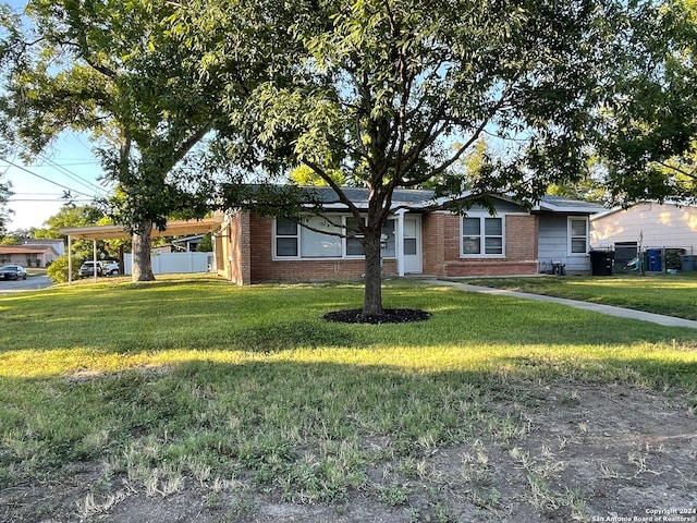 ranch-style house with a front yard and a carport