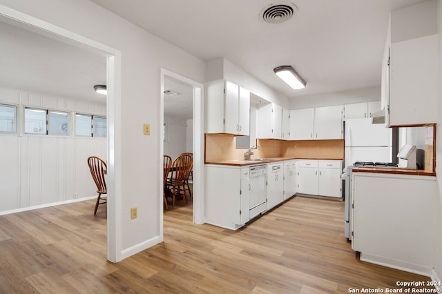 kitchen with light hardwood / wood-style flooring, backsplash, sink, white cabinetry, and white appliances