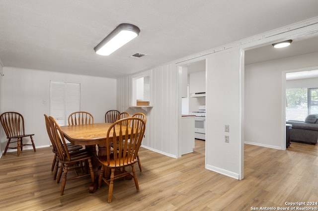 dining area with light hardwood / wood-style flooring and a textured ceiling