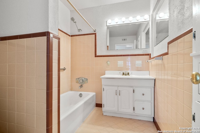 bathroom with vanity, bathtub / shower combination, tile walls, and tile patterned flooring