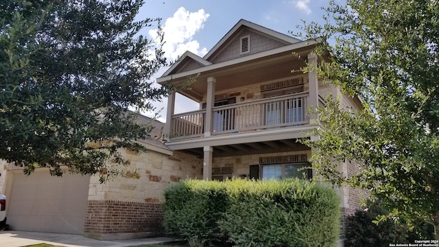 view of front of property with stone siding and a balcony