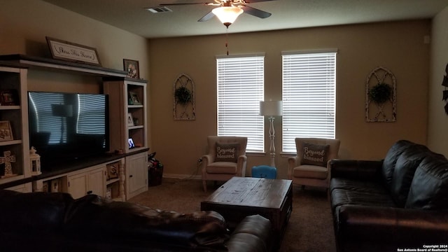 living area with carpet floors, visible vents, and a ceiling fan