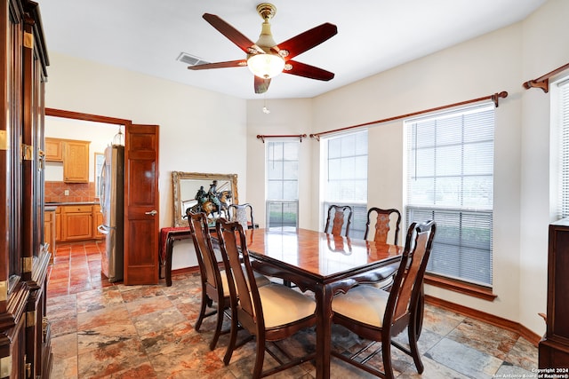 tiled dining space with ceiling fan