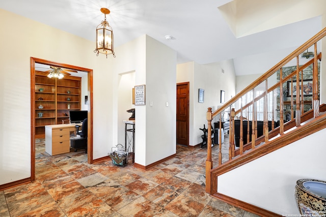 tiled entrance foyer featuring high vaulted ceiling and ceiling fan with notable chandelier