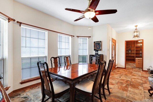 tiled living room featuring ceiling fan, high vaulted ceiling, beamed ceiling, and a stone fireplace