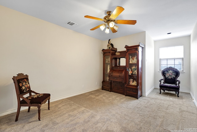 living area with ceiling fan and light carpet