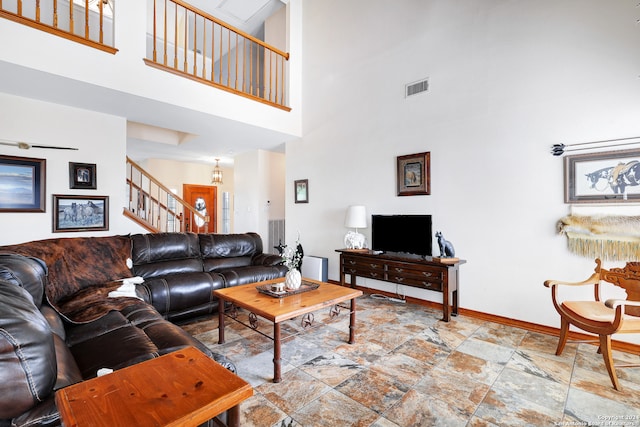 living room with light tile patterned floors and a high ceiling