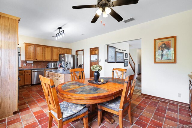 kitchen with sink, backsplash, dark tile patterned flooring, black appliances, and a chandelier