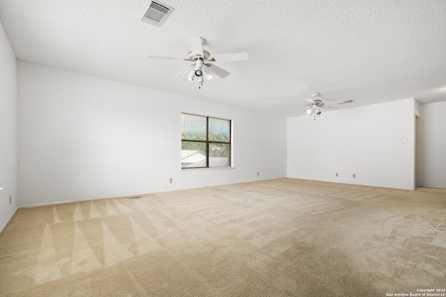 carpeted spare room with a textured ceiling and ceiling fan