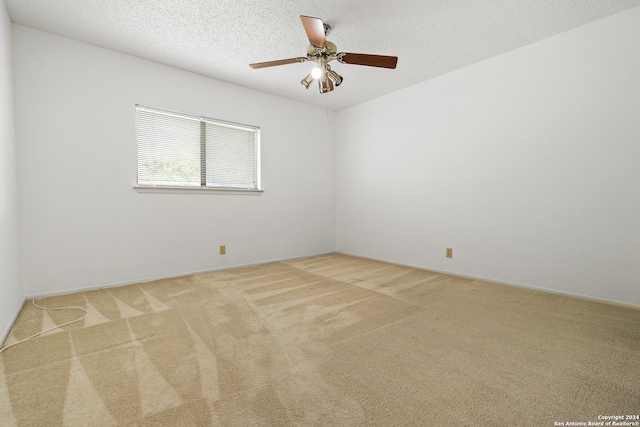 empty room featuring light colored carpet, a textured ceiling, and ceiling fan