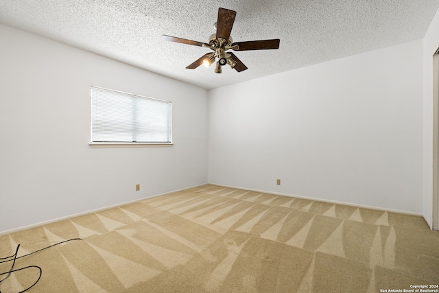 spare room featuring a textured ceiling, ceiling fan, and light colored carpet