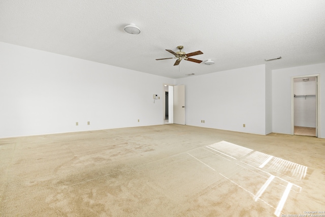 spare room with light carpet, a textured ceiling, and ceiling fan