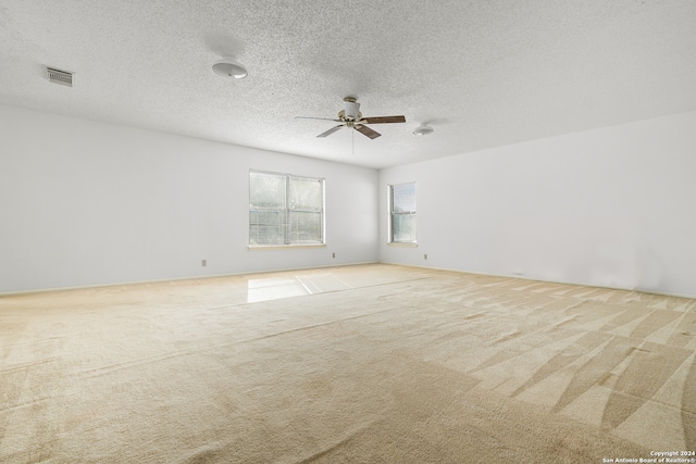 carpeted empty room with a textured ceiling and ceiling fan