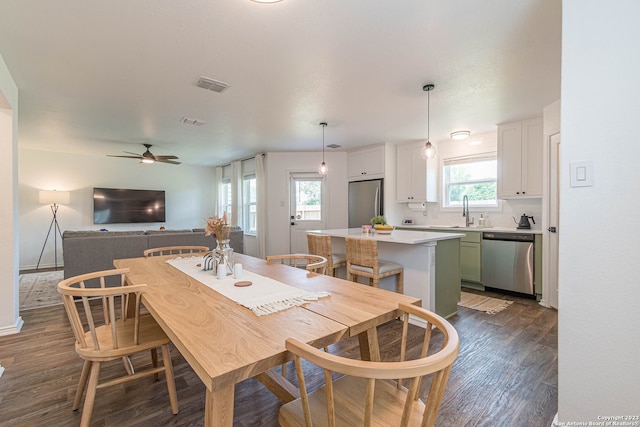 dining area with sink, dark wood-type flooring, ceiling fan, and a healthy amount of sunlight