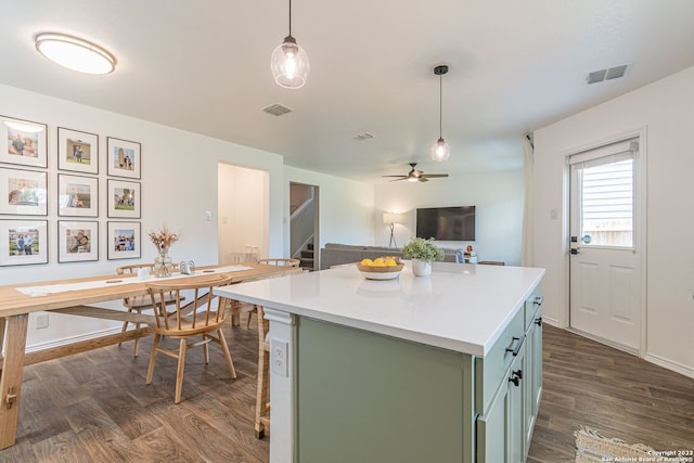 kitchen with ceiling fan, dark hardwood / wood-style flooring, pendant lighting, a center island, and green cabinetry