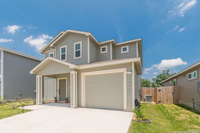 view of front of home featuring a garage, central AC, and a front yard