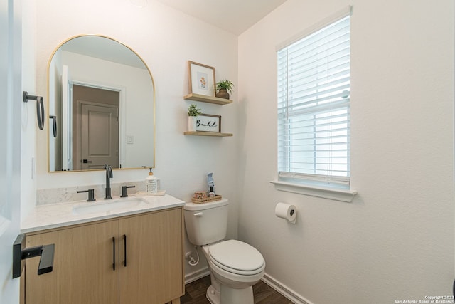 bathroom with hardwood / wood-style flooring, toilet, and vanity