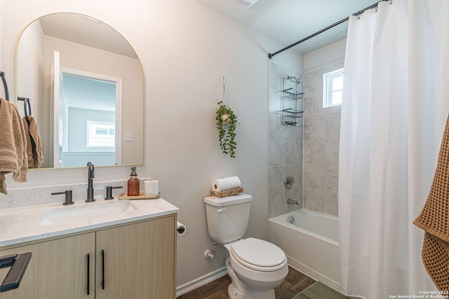 full bathroom featuring hardwood / wood-style flooring, a wealth of natural light, toilet, and vanity