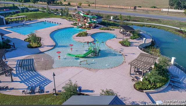 view of pool featuring a water slide and a patio area