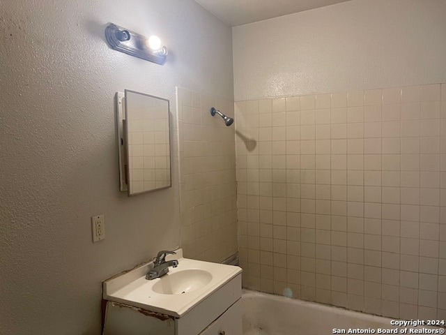 bathroom with vanity and tiled shower / bath