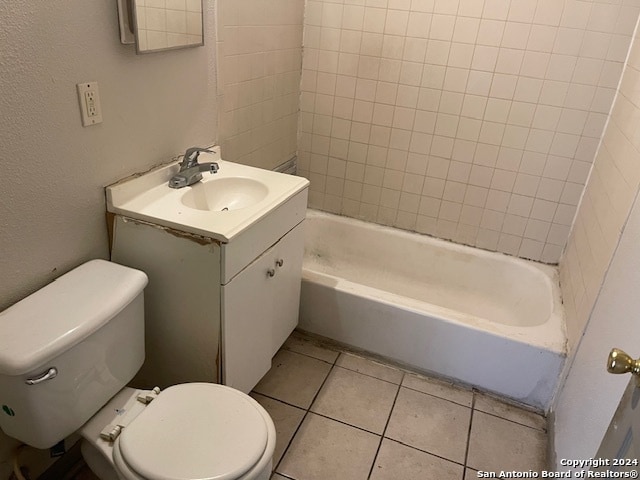 full bathroom with tiled shower / bath combo, vanity, tile patterned floors, and toilet