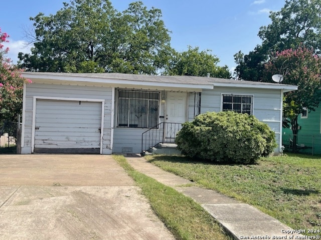 single story home with a garage and a front lawn