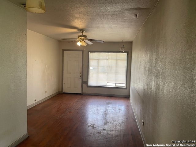 empty room featuring a textured ceiling, hardwood / wood-style flooring, and ceiling fan