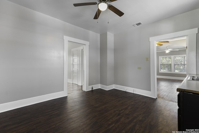 empty room with dark wood-type flooring, sink, and ceiling fan