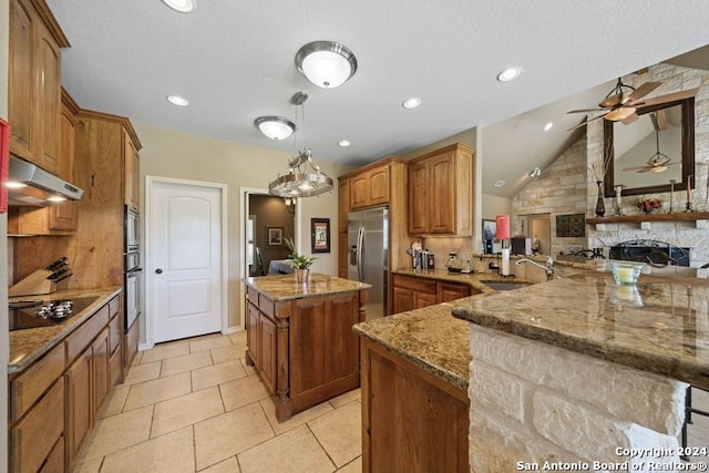 kitchen with a kitchen island, sink, hanging light fixtures, light stone counters, and stainless steel appliances