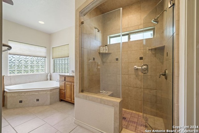 bathroom with tile patterned flooring, shower with separate bathtub, a healthy amount of sunlight, and vanity