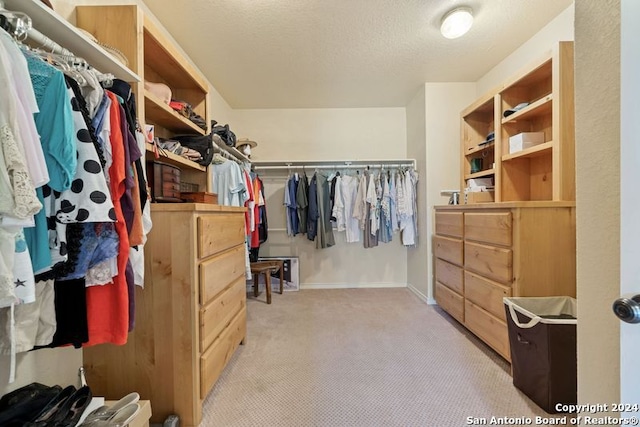 walk in closet featuring light colored carpet