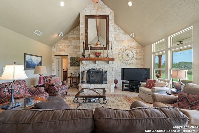 living room with a stone fireplace and high vaulted ceiling