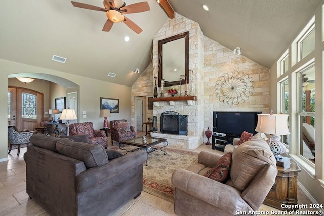 living room with french doors, high vaulted ceiling, beamed ceiling, ceiling fan, and a fireplace