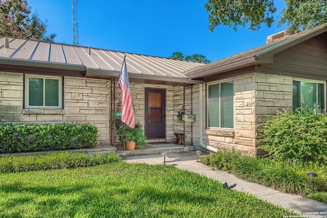 entrance to property with a lawn