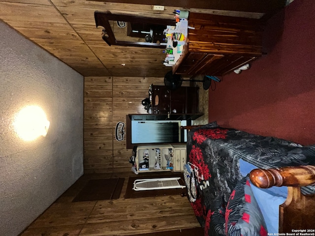 bedroom with wood walls and wood-type flooring