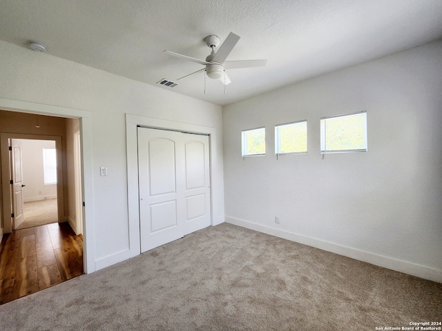 unfurnished bedroom with a closet, carpet floors, and ceiling fan