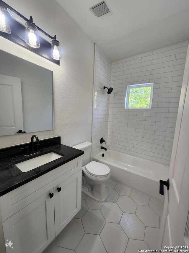 full bathroom featuring tile patterned floors, toilet, vanity, and tiled shower / bath