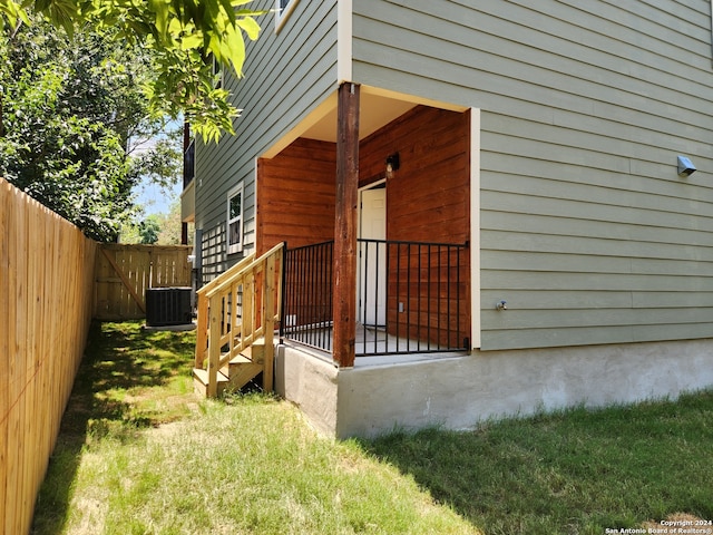 exterior space featuring cooling unit and a yard