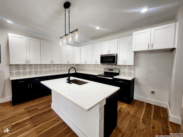 kitchen featuring white cabinetry, an island with sink, hardwood / wood-style floors, and stainless steel appliances