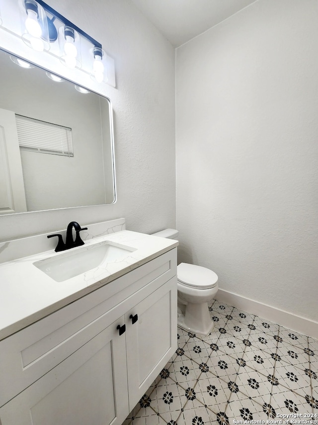 bathroom with tile patterned flooring, toilet, and vanity