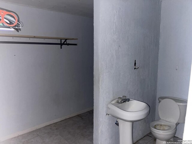 bathroom featuring baseboards and toilet