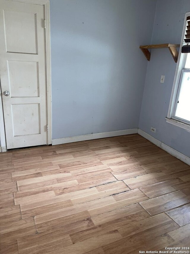 unfurnished room featuring baseboards and light wood-style floors