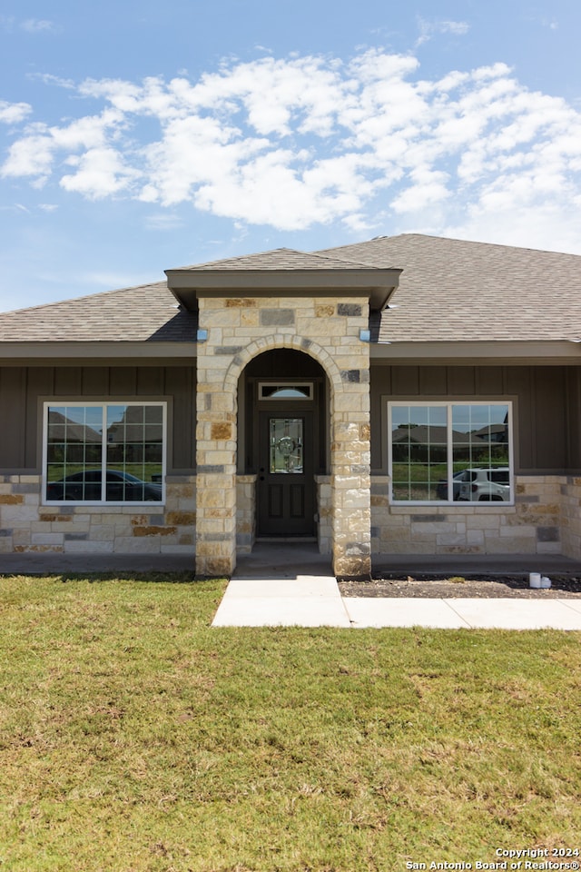 property entrance featuring a lawn