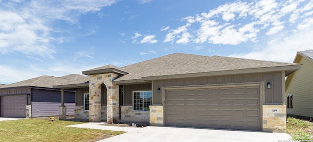 view of front facade featuring driveway, stone siding, a garage, and board and batten siding