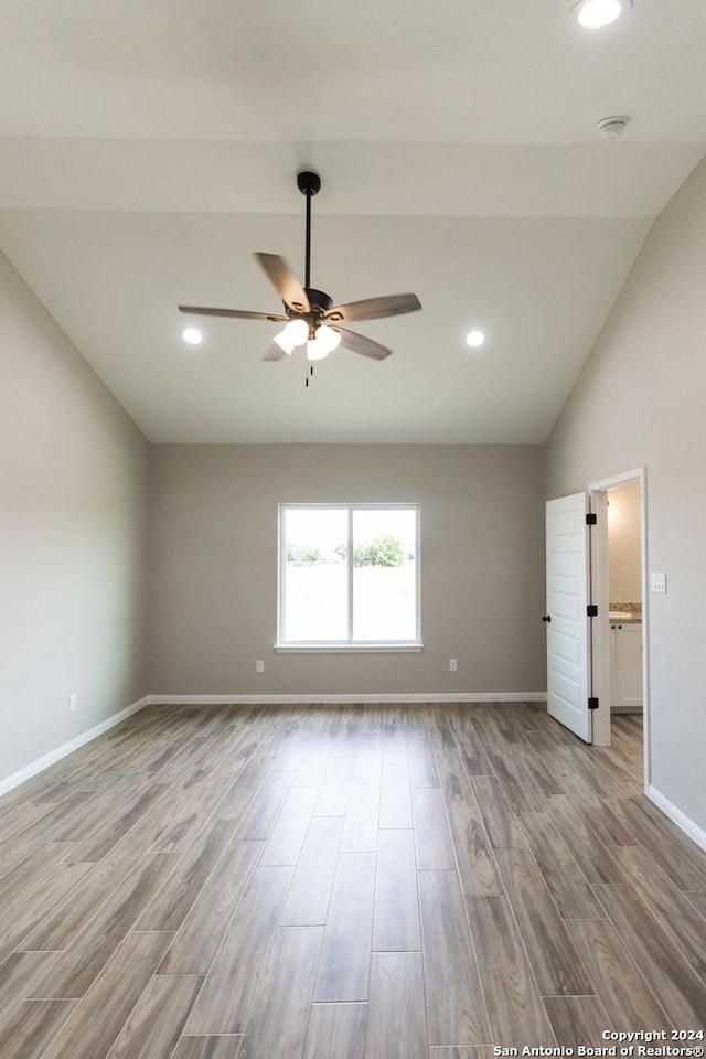 empty room featuring baseboards, lofted ceiling, light wood-style flooring, ceiling fan, and recessed lighting