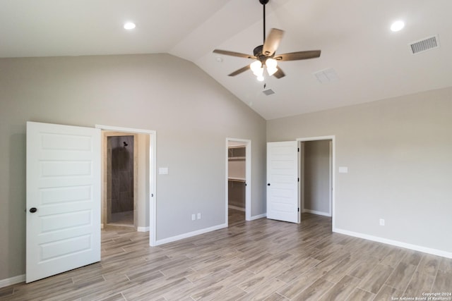 unfurnished bedroom featuring light wood finished floors, a walk in closet, visible vents, and baseboards