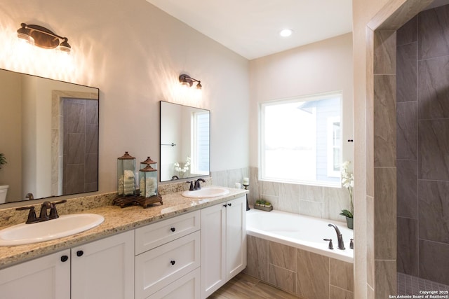 full bathroom with a garden tub, a sink, and double vanity