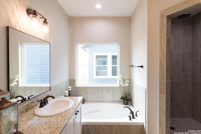 full bath with tiled shower, a garden tub, and vanity