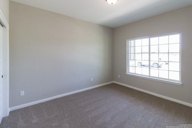 carpeted spare room with baseboards