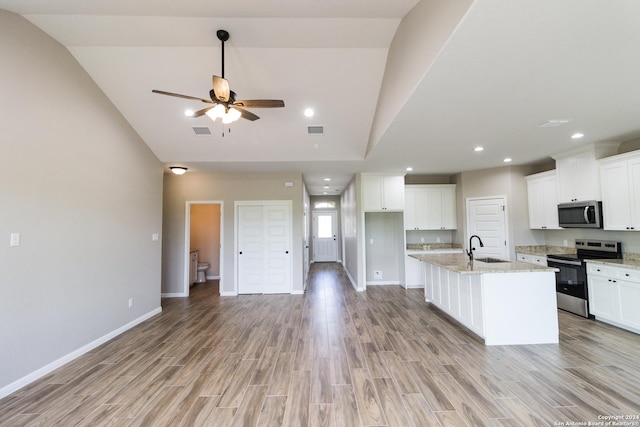 kitchen featuring light stone counters, a kitchen island with sink, stainless steel appliances, visible vents, and white cabinets